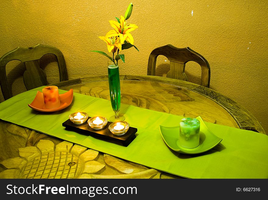 A table with candles and flowers, in an intimate corner of the home. A table with candles and flowers, in an intimate corner of the home