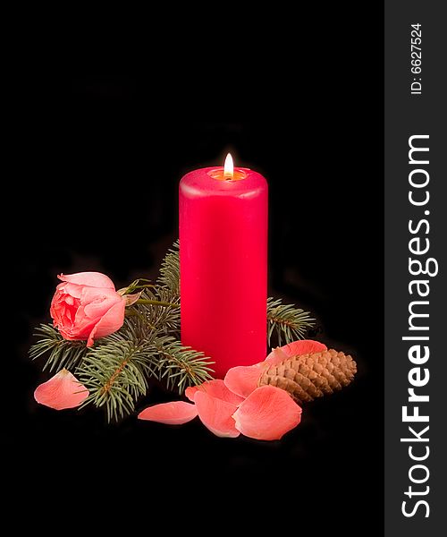 Candle red with flame and scarlet rose with petals on a black background