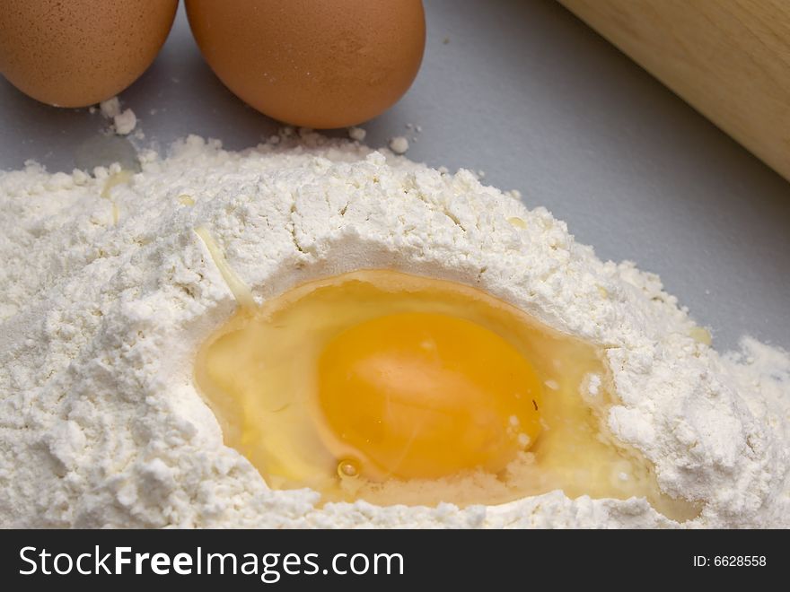 Flour and eggs on a kitchen table for preparation a dough