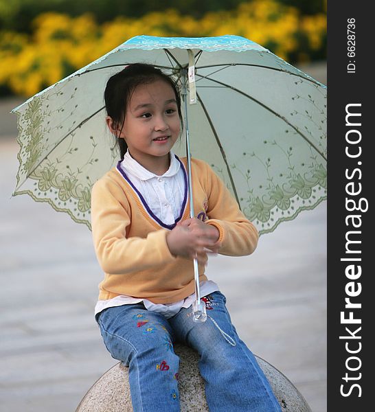 The smiling girl with a umbrella in a park .