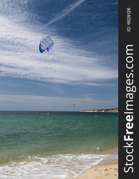 Kitesurfing near  Tarifa blue sky and sandy beach
