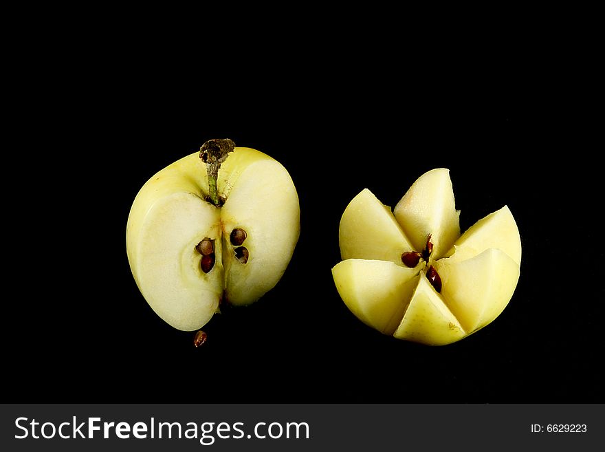 Two cutted yellow apples on black