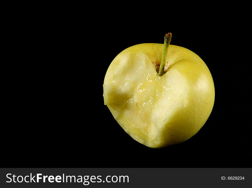 Yellow bitten apple  on black. Yellow bitten apple  on black