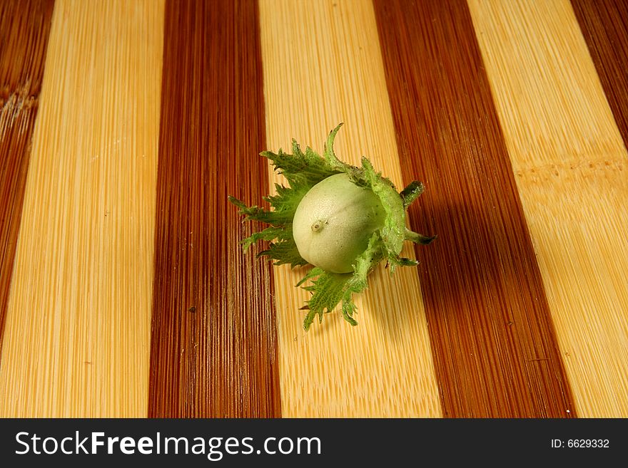 Green filbert on wooden surface