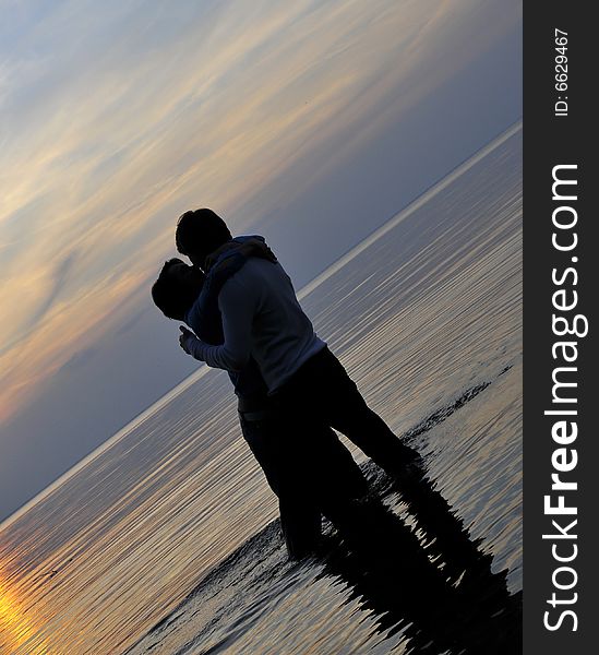 Two silhouettes of in love pair on a background sunset. Two silhouettes of in love pair on a background sunset