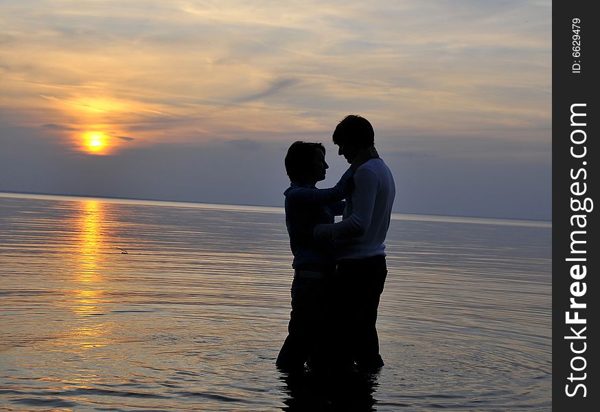 Two silhouettes of in love pair on a background sunset. Two silhouettes of in love pair on a background sunset