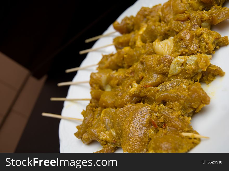 Close up of chicken satay skewers that are about to be barbequed