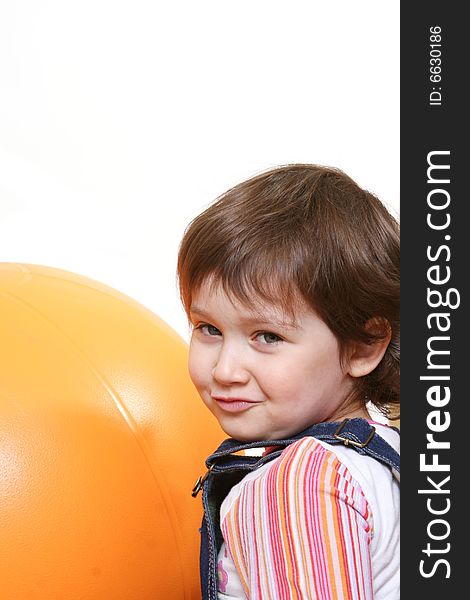 Little girl playing with big orange ball