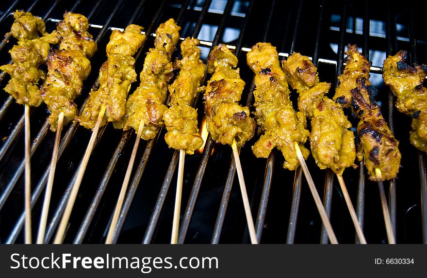 Chicken satay being bbqed on a grill. Chicken satay being bbqed on a grill