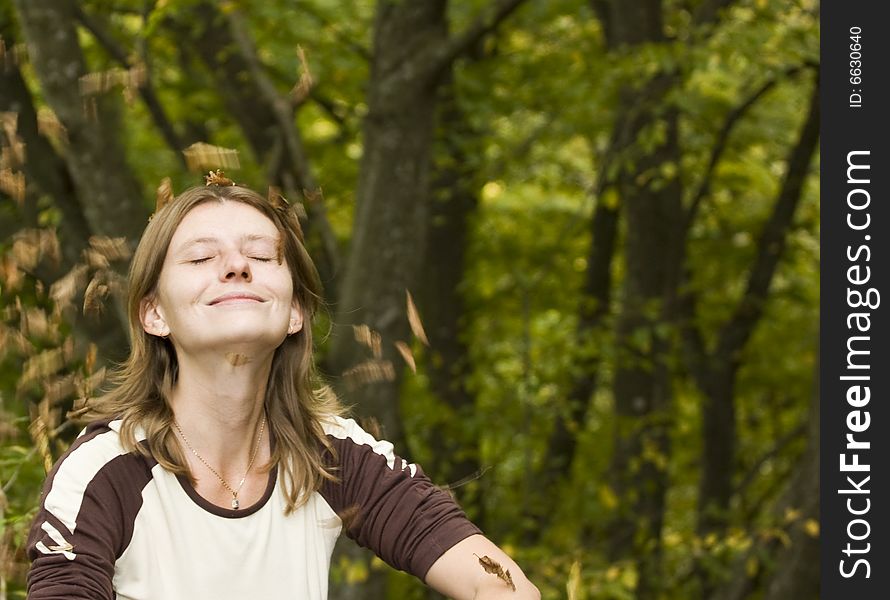 Girl relaxing in autumn park with falling leaves. Girl relaxing in autumn park with falling leaves