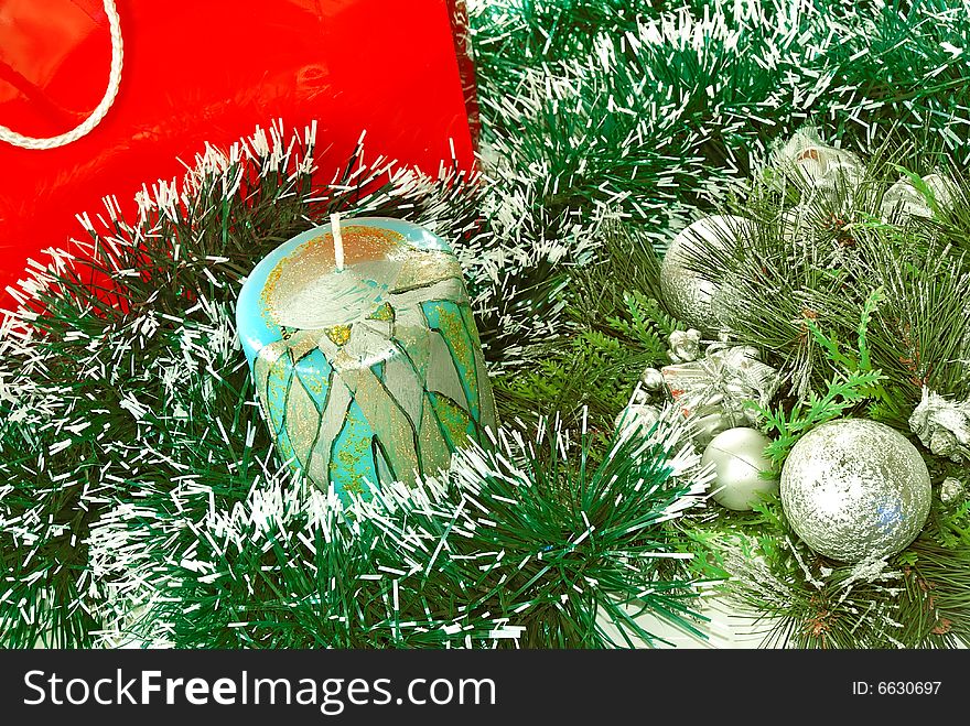 Decorative candle over green new year adorning. Decorative candle over green new year adorning