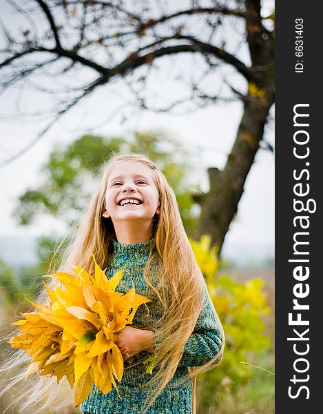 Funny little girl holding autumn leaves. Funny little girl holding autumn leaves