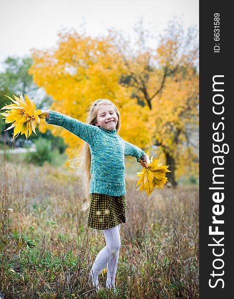 Cute girl with hands open over autumn background