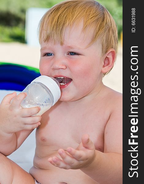 Portrait of the laughing child with a bottle of milk. Portrait of the laughing child with a bottle of milk