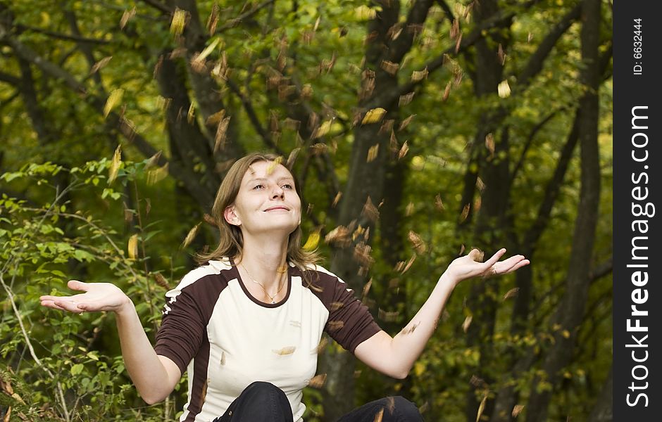 Girl relaxing in autumn park with falling leaves. Girl relaxing in autumn park with falling leaves