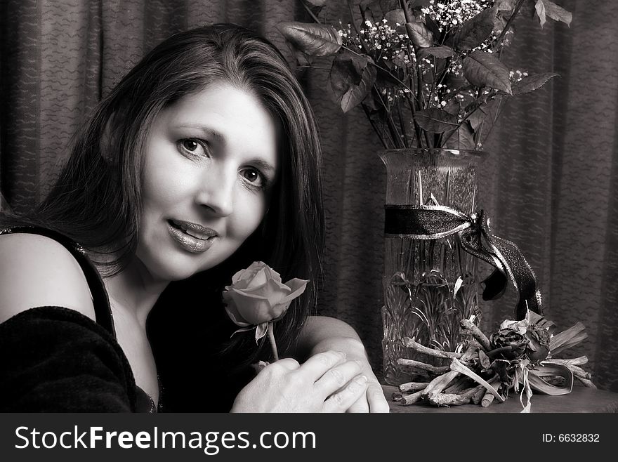 Brunette model holding a rose, looking at the camera