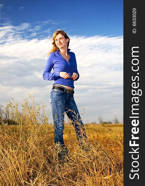 The girl in an autumn field against the sky. The girl in an autumn field against the sky