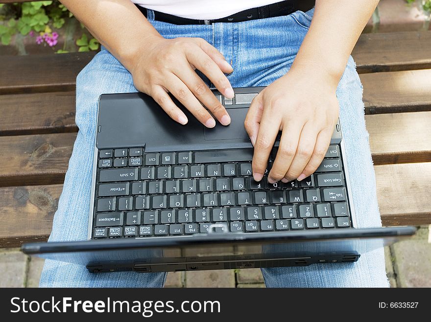 A young man using a laptop in the park