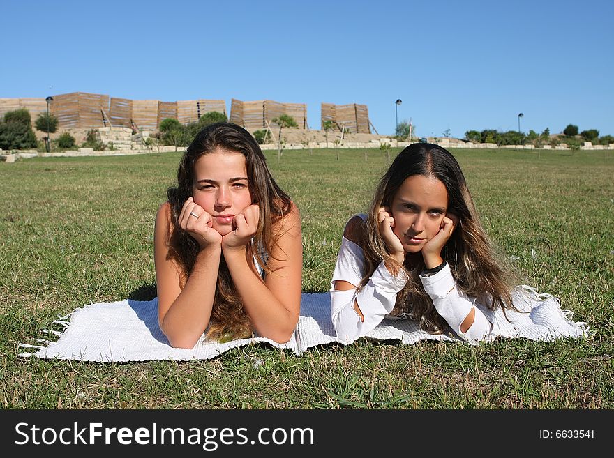 Two beautiful young women relaxing in the grass. Two beautiful young women relaxing in the grass