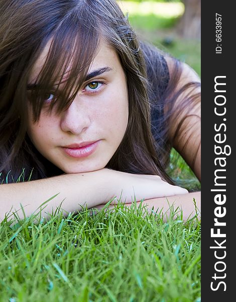 Young staring woman laying on the grass. Young staring woman laying on the grass