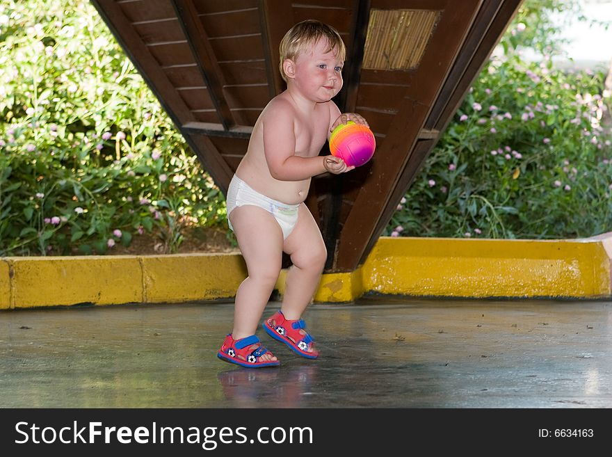 Small child plays a ball on a children's playground