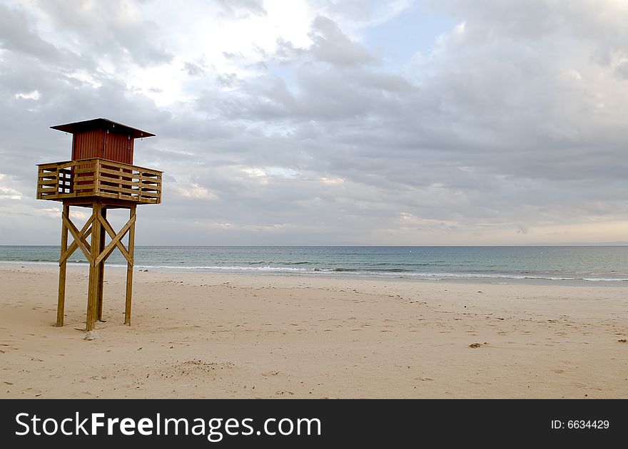 Empty beach with watchtower sunset