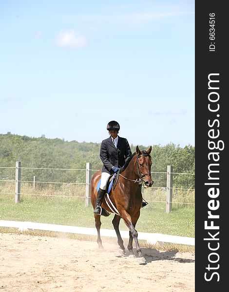 African American teenage girl riding a brown horse with dust from the ground. African American teenage girl riding a brown horse with dust from the ground