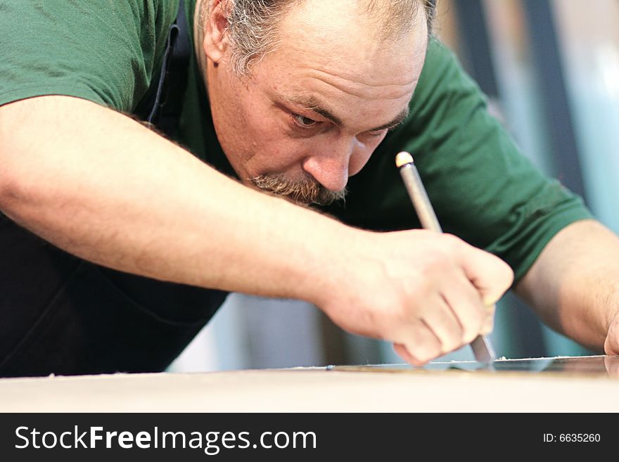 The worker, cutting a mirror,fokus on a face