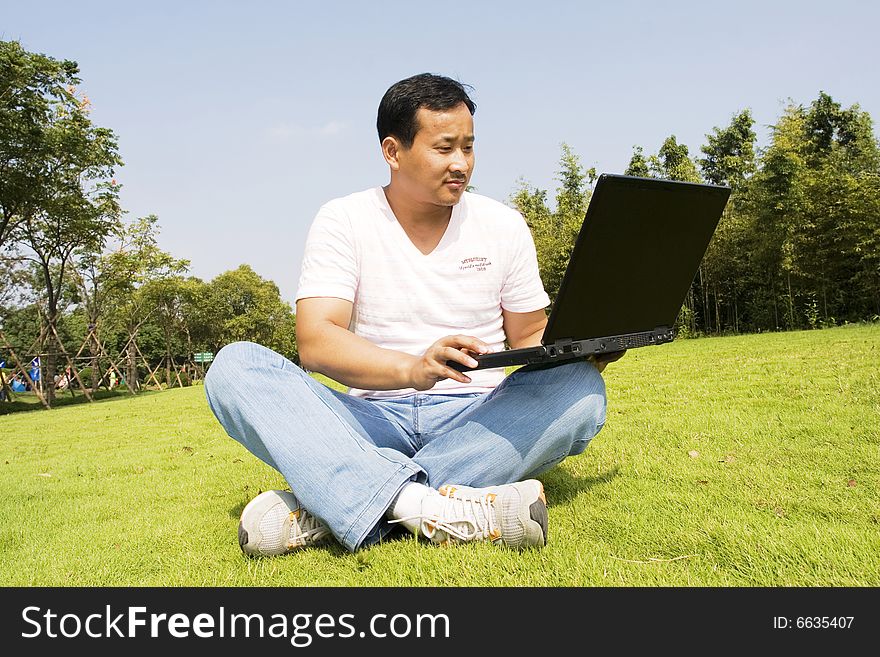 A young man using a laptop outdoors