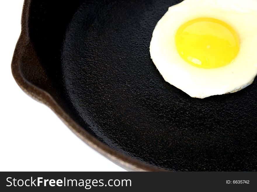 Fresh organic egg frying in a seasoned cast-iron skillet. Fresh organic egg frying in a seasoned cast-iron skillet