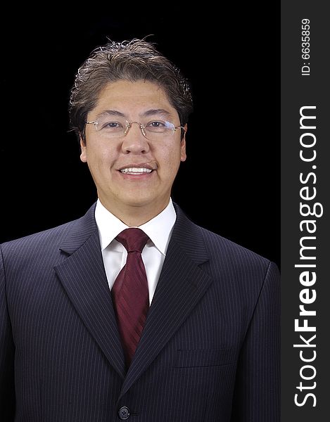 Attractive asian businessman in a suit over a black background. Attractive asian businessman in a suit over a black background