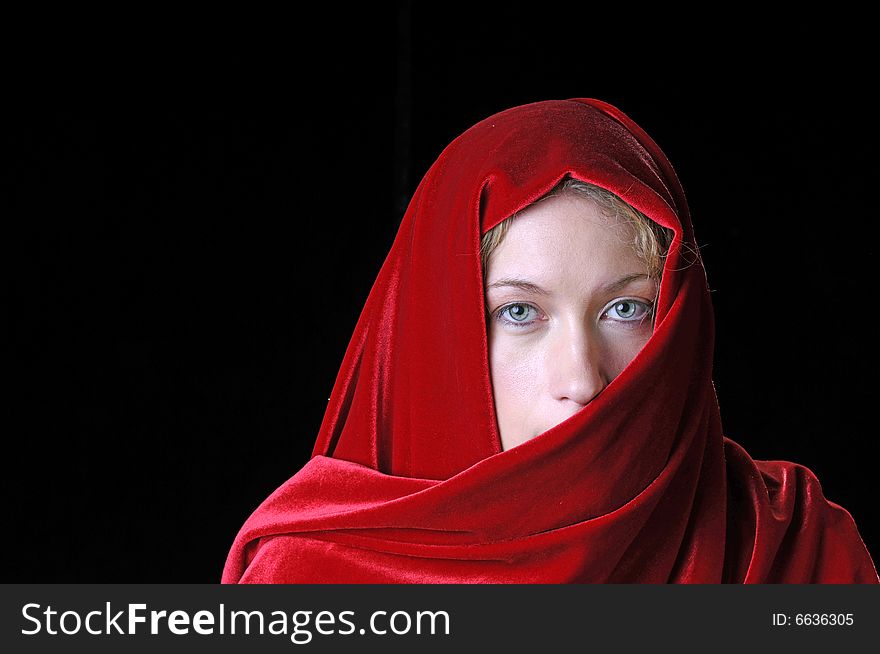 Beautiful young blond woman in closeup with shawl over her face