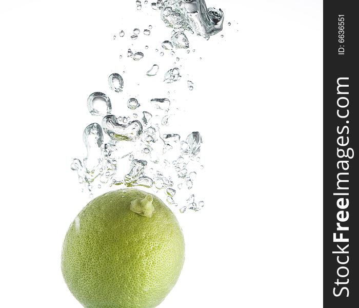 Single green lime pouring in water with  bubbles train. Single green lime pouring in water with  bubbles train