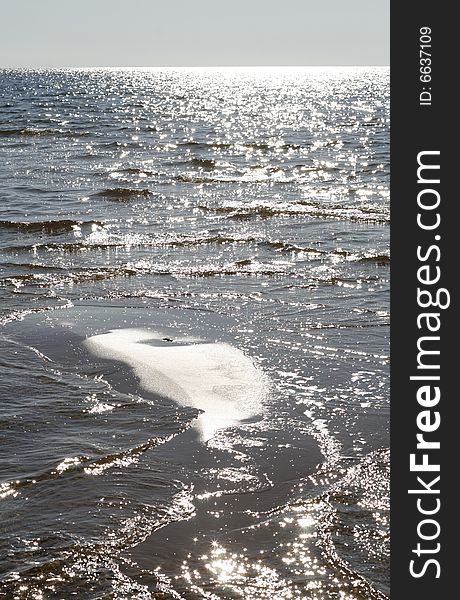 Beach view of a sparkling water surface. Beach view of a sparkling water surface