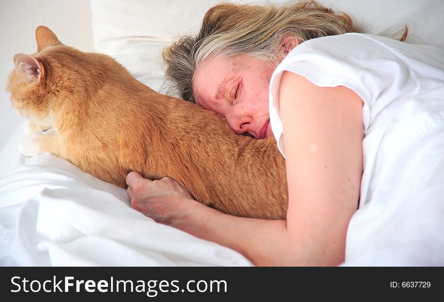 Woman and her cat relaxing in bed.