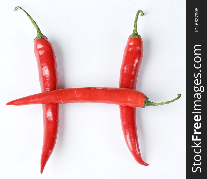 Red Chillies in the shape of H on white