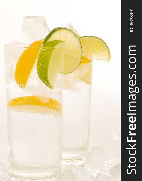 Sparkling water with slices of fresh lemon and lime on a white background. Sparkling water with slices of fresh lemon and lime on a white background.
