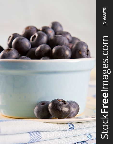 Dish of fresh blueberries on a blue and white cloth