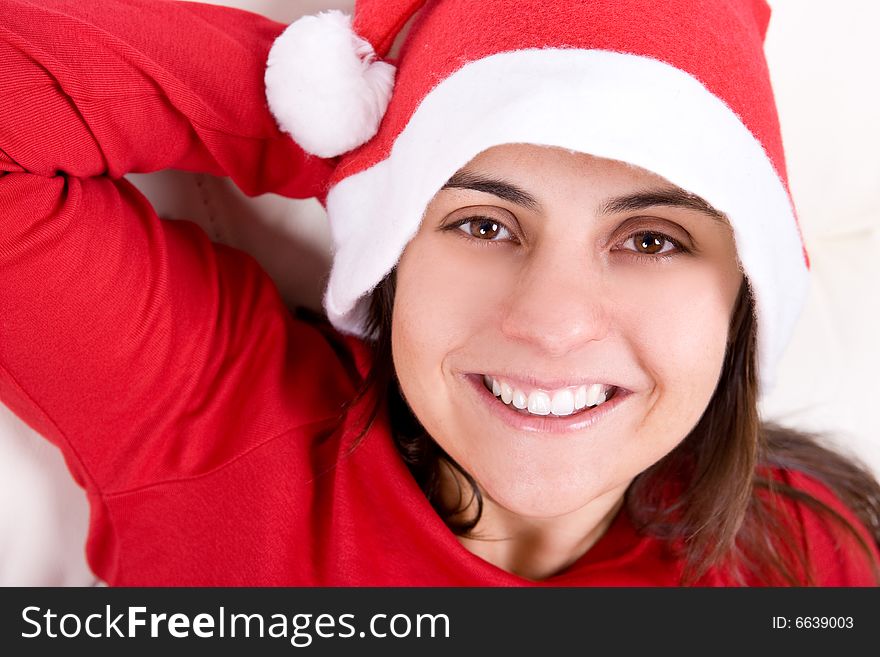 Beautiful young woman with red christmas hat smiling