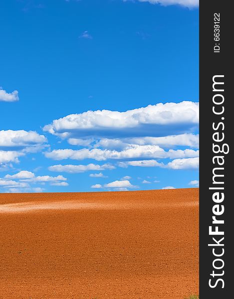 An image of the agricultural land with blue sky and white clouds. An image of the agricultural land with blue sky and white clouds