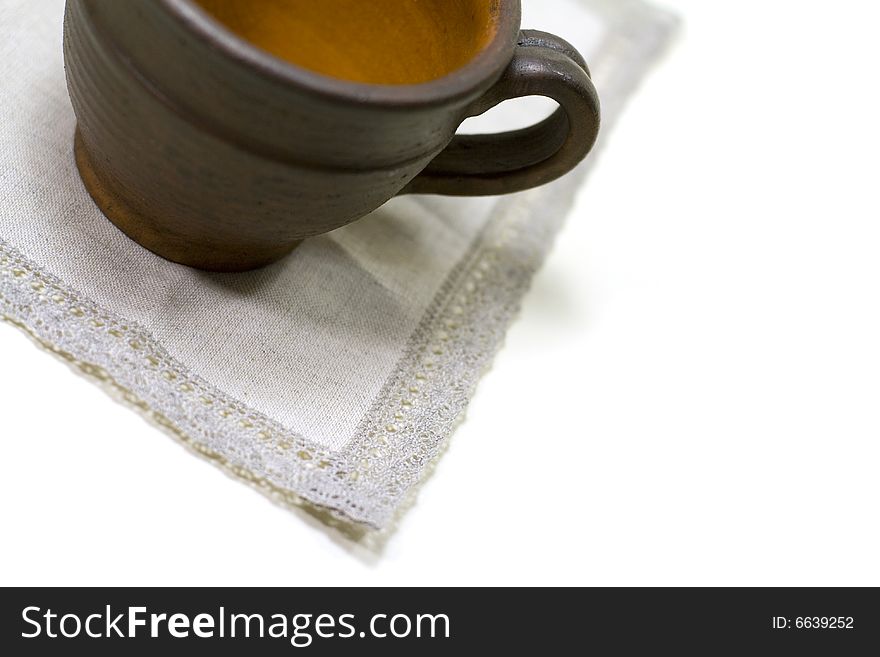 Empty coffee cup and linen napkin on white background
