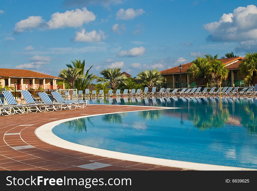 Resort swimming pool under a clear tropical sky. Resort swimming pool under a clear tropical sky.