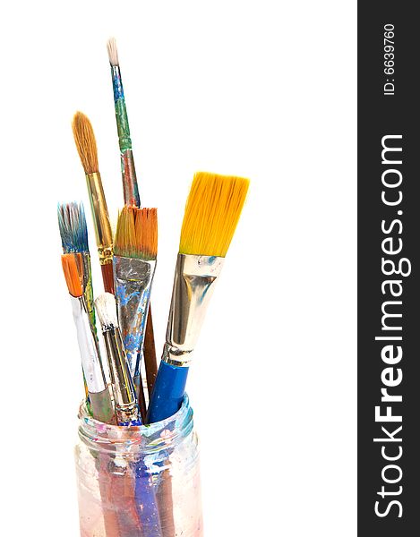 Colorful paint brushes sitting in a glass jar. Colorful paint brushes sitting in a glass jar