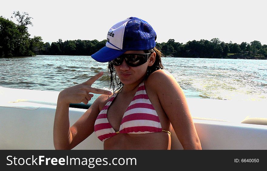 Teen girl being silly on the back of a boat in the summertime. Teen girl being silly on the back of a boat in the summertime.