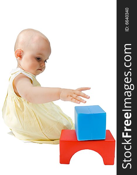 Little baby girl playing with her toys, building, isolated on white