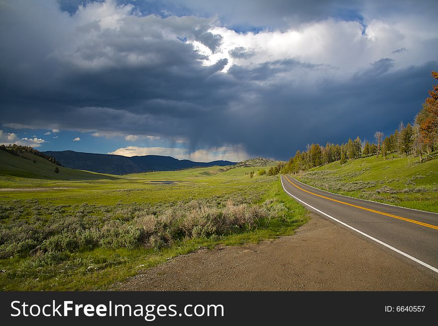 A road leading to a storm in Yellowstone National Park. A road leading to a storm in Yellowstone National Park