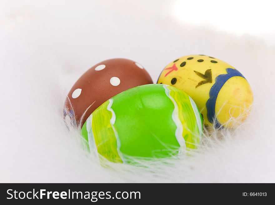 Colorful Easter eggs isolated on a white feathers