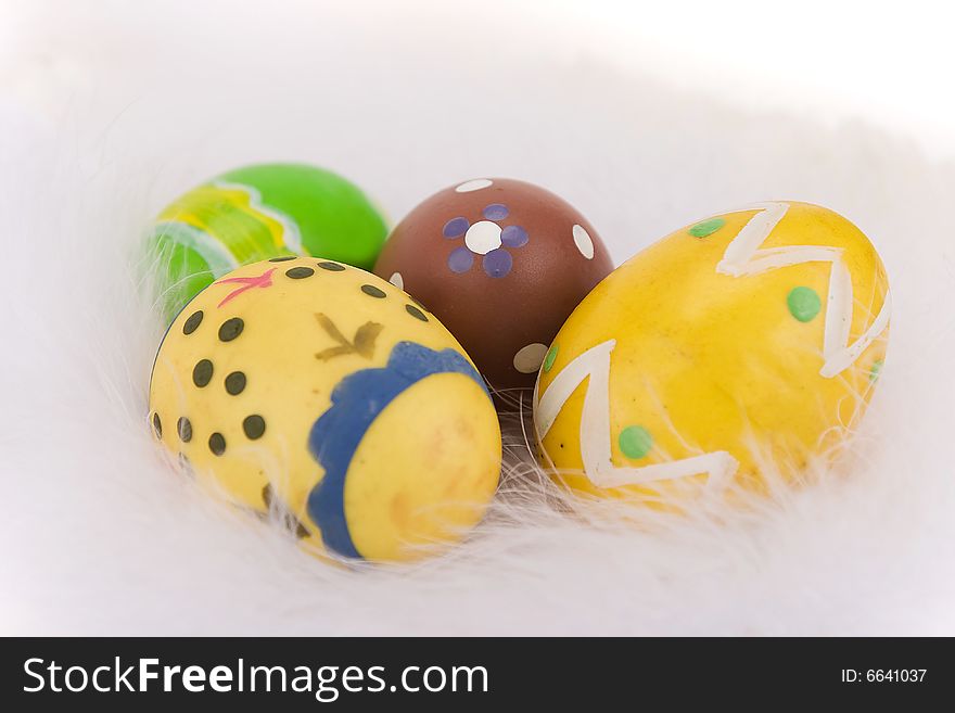Colorful Easter eggs isolated on a white feathers