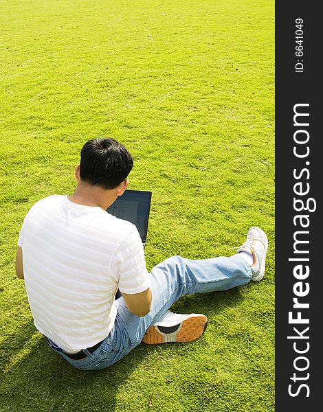 A young man using a laptop outdoors