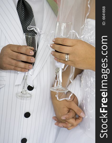 Torso of a bride and groom with bride's ring visible sharing a toast. Torso of a bride and groom with bride's ring visible sharing a toast.